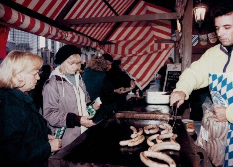 German Vendor Serving Bratwurst at the First Christkindlmarket